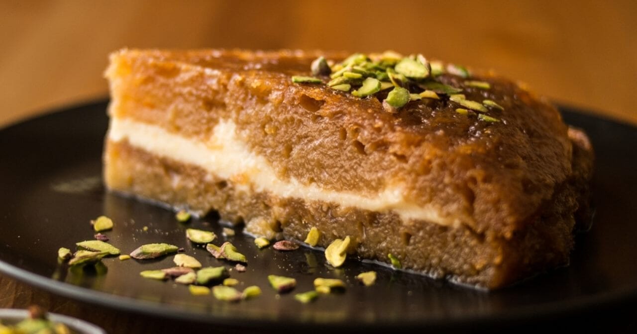 bir tabağın içerisindeki, üzerine fıstık serpilmiş ekmek kadayıfı tatlısı