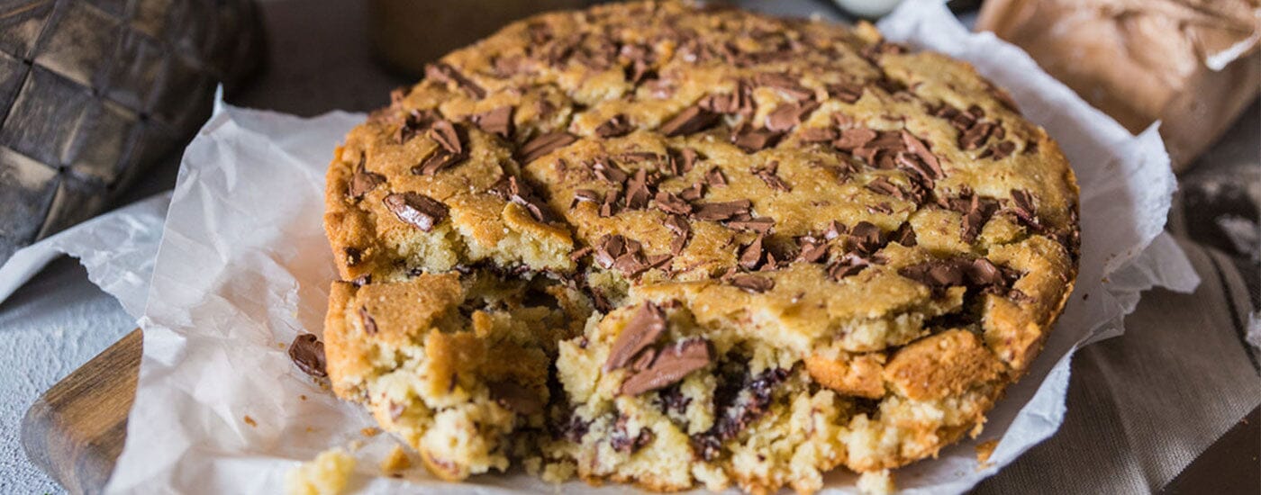 büyük bir tabakta hazırlanmış olarak sunulan dev cookie cake