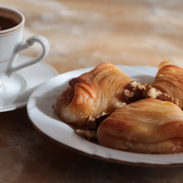 bir masanın üzerinde duran bir fincan Türk kahvesi ve bir tabak midye tatlısı tarifi
