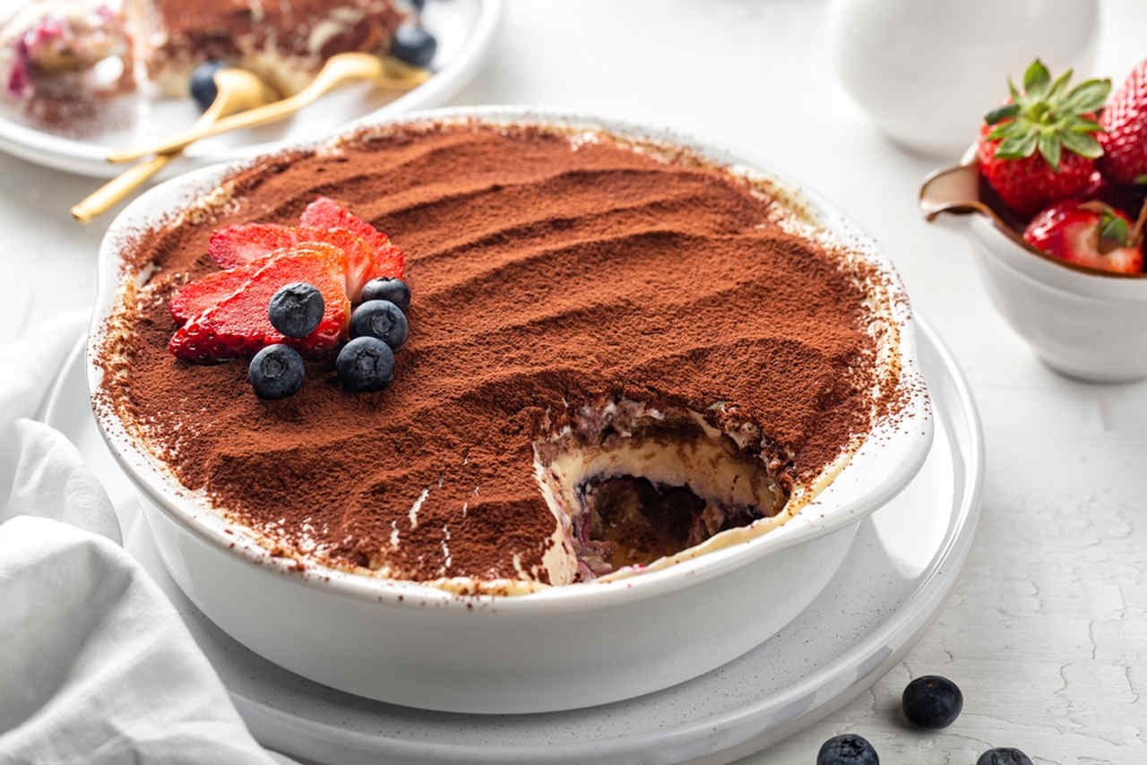 bir tepsi tiramisu ve üstünde çilek ve üzüm