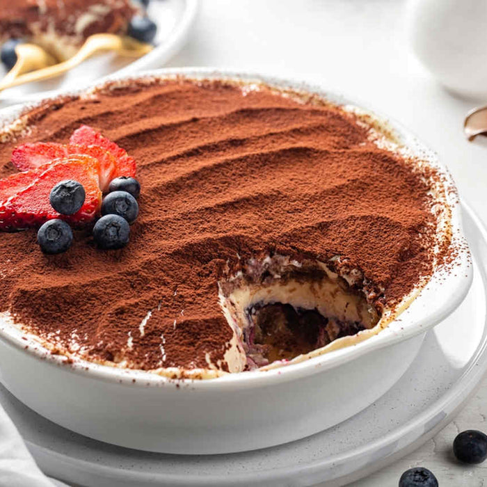bir tepsi tiramisu ve üstünde çilek ve üzüm