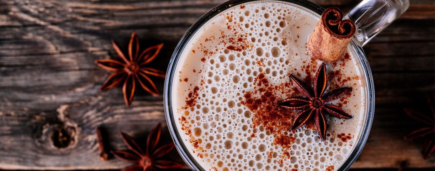 ahşap zemin üzerinde duran bir fincan chai tea latte'ye yukarıdan bakış