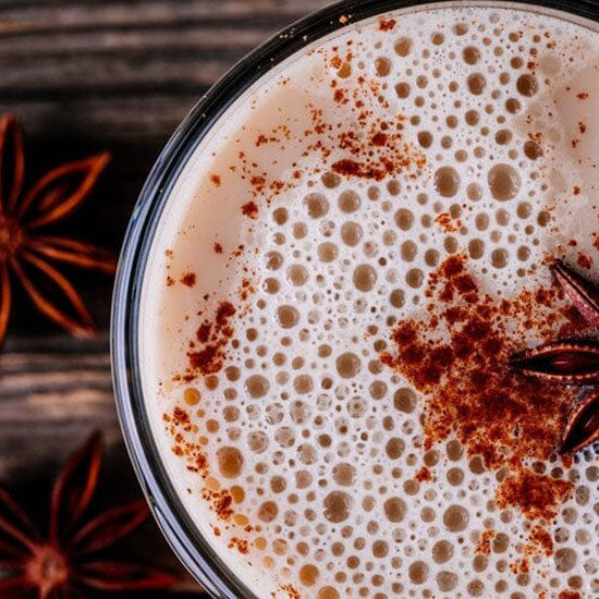 ahşap zemin üzerinde duran bir fincan chai tea latte'ye yukarıdan bakış