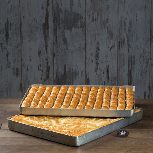 bir tepsi börek ve üzerinde duran bir tepsi baklava