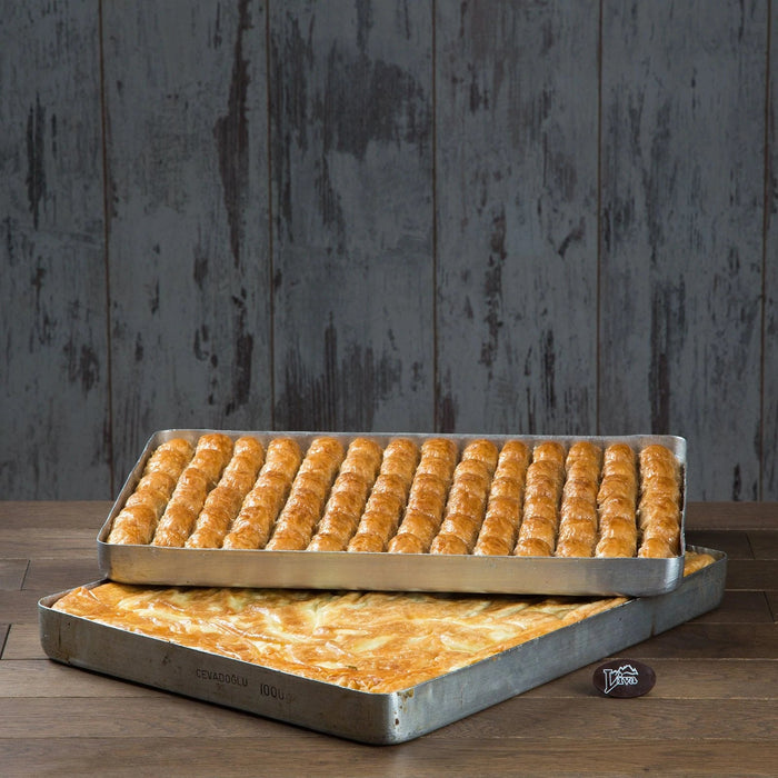 bir tepsi börek ve üzerinde duran bir tepsi baklava